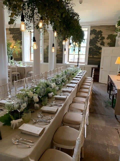 Long table decorated for wedding with green leaves