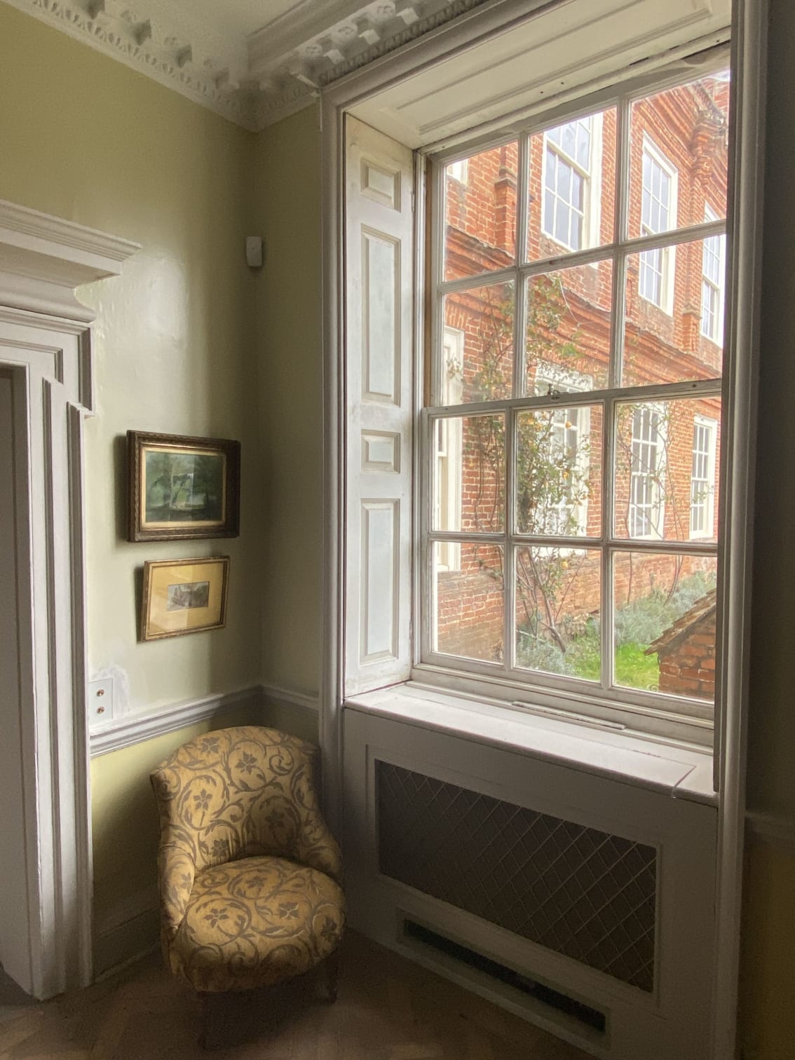 A sash window and small armchair in the Morning Room