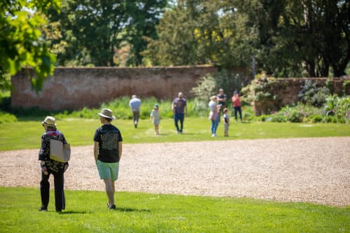 people strolling in front of garden wall