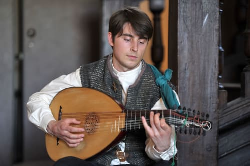 a lute player strums his instrument