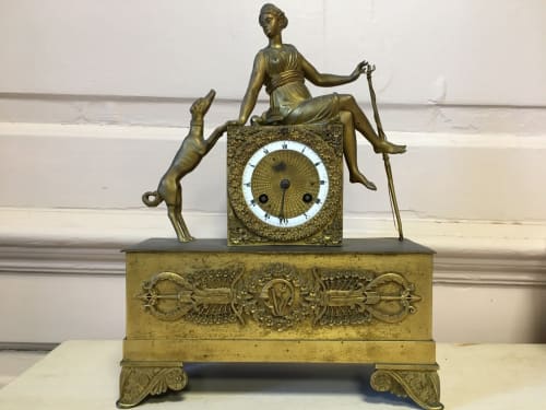 gilt clock with figure of woman with bow and dog